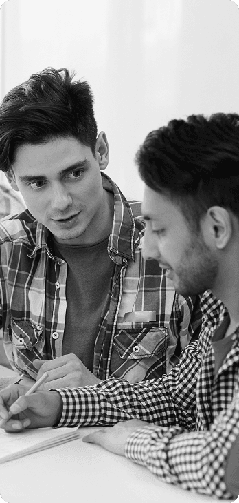 Two young men in discussion, one wearing plaid shirt and another in checkered shirt