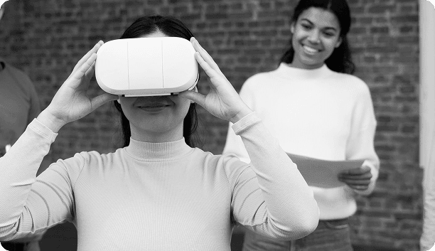 Woman using VR headset with colleague in background